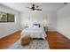 Sunlit bedroom with ceiling fan, wood floors, area rug, and a neatly arranged bed with a decorative pillow at 108 Biscayne Ave # B, Tampa, FL 33606