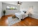 Bright bedroom featuring a window with trees and a bed with a decorative pillow and wood floors at 108 Biscayne Ave # B, Tampa, FL 33606