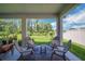 Relaxing back porch featuring comfortable seating and a serene view of the backyard and water at 10945 Sundrift Dr, Tampa, FL 33647
