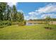 Expansive backyard featuring lush green grass, a serene pond, and a beautiful natural backdrop with mature trees at 10945 Sundrift Dr, Tampa, FL 33647