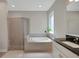 Bright bathroom featuring a shower with glass door and a soaking tub beneath a large window at 10945 Sundrift Dr, Tampa, FL 33647