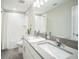 A well-lit bathroom features a large mirror, modern vanity with double sinks, and a clean, tiled shower/tub combo at 10945 Sundrift Dr, Tampa, FL 33647