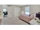 A bedroom featuring plush carpeting, a comfortable bed with stylish bedding, and a spacious closet for ample storage at 10945 Sundrift Dr, Tampa, FL 33647