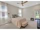 Bright bedroom with large windows, ceiling fan, and a view of the backyard at 10945 Sundrift Dr, Tampa, FL 33647