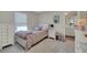 This bedroom has a white bed frame, a cream-colored rug, and a large window that lets in plenty of natural light at 10945 Sundrift Dr, Tampa, FL 33647