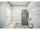 Neat laundry room featuring washer, dryer, storage shelves, and gray tile flooring at 10945 Sundrift Dr, Tampa, FL 33647