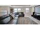 Loft features a large leather sectional, media screen, and a trio of bright windows at 10945 Sundrift Dr, Tampa, FL 33647