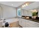 The main bathroom features double sinks with granite counters, a tub, and a window at 10945 Sundrift Dr, Tampa, FL 33647
