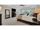 This main bedroom features a dresser with TV, mirror and a tray ceiling with fan at 10945 Sundrift Dr, Tampa, FL 33647