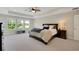 This bright main bedroom features a ceiling fan, carpet floors, and large windows at 10945 Sundrift Dr, Tampa, FL 33647