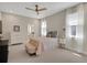 Main bedroom with neutral carpet, ceiling fan, and view into the bathroom at 10945 Sundrift Dr, Tampa, FL 33647