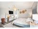 Well-lit bedroom featuring modern decor, wood floors, floating entertainment center, and lots of natural light at 1106 Humble Haven St, Ruskin, FL 33570