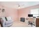 Cozy bedroom with a ceiling fan, comfortable chair, desk and computer setup in a neutral color palette at 1106 Humble Haven St, Ruskin, FL 33570