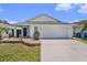Charming single-story home features a well-manicured lawn, a two-car garage, and a welcoming covered front porch at 1106 Humble Haven St, Ruskin, FL 33570