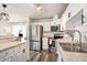 Stylish kitchen features stainless steel appliances, granite countertops, white cabinetry and wood flooring at 1106 Humble Haven St, Ruskin, FL 33570