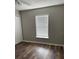 A vacant bedroom with dark wood flooring offers a bright window and bi-fold door closet at 11102 Summer Star Dr, Riverview, FL 33579