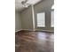 A vacant bedroom featuring tall ceilings, dark wood flooring, and natural light from two windows at 11102 Summer Star Dr, Riverview, FL 33579
