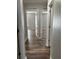 Hallway featuring wood-like flooring and white doors leading to various rooms in the home at 11102 Summer Star Dr, Riverview, FL 33579
