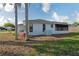 Rear view of a home with a well-manicured lawn and partial fencing at 11305 Brown Bear Ln, Port Richey, FL 34668