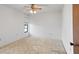 Bright bedroom with a ceiling fan, window, and neutral-colored walls and carpet at 11305 Brown Bear Ln, Port Richey, FL 34668