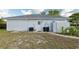 Rear view of a home with a white door, AC unit and trashcans at 11305 Brown Bear Ln, Port Richey, FL 34668