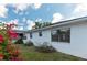 Exterior view of house featuring pink flowering bushes and several windows at 11305 Brown Bear Ln, Port Richey, FL 34668