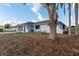Single-story home featuring white exterior, well-maintained yard, and mature landscaping at 11305 Brown Bear Ln, Port Richey, FL 34668