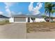 Charming single-story home featuring a screened-in two-car garage and well-lit concrete driveway at 11305 Brown Bear Ln, Port Richey, FL 34668