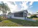 The back of the home shows a cozy screened in lanai, and a small landscaped area with a palm tree at 11305 Brown Bear Ln, Port Richey, FL 34668