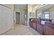 Bathroom featuring a double sink vanity with granite countertop and a glass-enclosed shower at 11408 Coventry Grove Cir, Lithia, FL 33547