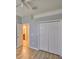 Bedroom with light hardwood floors, a ceiling fan, double closets, and a doorway to the ensuite bathroom at 11408 Coventry Grove Cir, Lithia, FL 33547