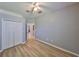 Bedroom featuring light hardwood floors, neutral paint, a ceiling fan, and a closet near a doorway at 11408 Coventry Grove Cir, Lithia, FL 33547