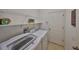 Bright laundry room with white appliances, wire shelving, and a wooden sign at 11408 Coventry Grove Cir, Lithia, FL 33547