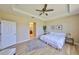 Cozy bedroom with wood floors, a ceiling fan, a view of the en-suite bathroom, and walk-in closet at 11408 Coventry Grove Cir, Lithia, FL 33547