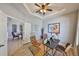 Home office features a modern desk, two leather chairs, light wood floors, and a door leading to another room at 11408 Coventry Grove Cir, Lithia, FL 33547