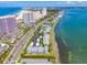 Aerial view features coastline with condo buildings, beachfront, and clear ocean waters at 1351 Gulf Blvd # 209, Clearwater Beach, FL 33767