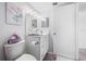 Cozy bathroom featuring white cabinetry, stylish vanity lighting, and a charming floral painting at 1351 Gulf Blvd # 209, Clearwater Beach, FL 33767
