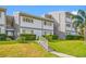 Low angle view of the property's exterior featuring lush landscaping and manicured lawn at 1351 Gulf Blvd # 209, Clearwater Beach, FL 33767