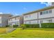 Well-maintained condo exterior featuring lush green lawn and clean, modern architectural design at 1351 Gulf Blvd # 209, Clearwater Beach, FL 33767