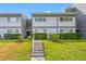 Charming condo exterior with manicured bushes, sidewalk, and cozy entrance stairs at 1351 Gulf Blvd # 209, Clearwater Beach, FL 33767