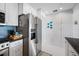 Kitchen with stainless refrigerator, white cabinets, and tiled backsplash at 1351 Gulf Blvd # 209, Clearwater Beach, FL 33767
