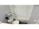 Clean bathroom features a tub and shower combination, toilet and functional storage shelves at 1400 Costa Mesa Dr, Wesley Chapel, FL 33543