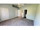 Bedroom with neutral walls, ceiling fan, closet, and views to the bath area at 1400 Costa Mesa Dr, Wesley Chapel, FL 33543