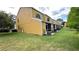 Exterior back view of a yellow stucco townhome at 1400 Costa Mesa Dr, Wesley Chapel, FL 33543