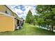 A yellow two-story townhouse with lush grass and lakeside views creates a tranquil and picturesque setting at 1400 Costa Mesa Dr, Wesley Chapel, FL 33543