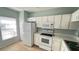 Functional kitchen featuring white appliances, ample storage, and a window for natural light at 1400 Costa Mesa Dr, Wesley Chapel, FL 33543