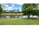 Scenic pond view with lush green lawn and trees reflected in the calm waters at 1400 Costa Mesa Dr, Wesley Chapel, FL 33543