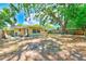 Large backyard with patio area, mature trees, and fully fenced yard at 1433 Spring Ln, Clearwater, FL 33755