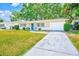 Well-maintained home with a spacious driveway and front lawn at 1433 Spring Ln, Clearwater, FL 33755