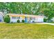 Charming home featuring a well-manicured lawn and landscaping at 1433 Spring Ln, Clearwater, FL 33755